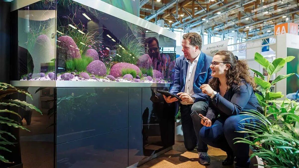 Visiteurs découvrant un aquarium sur un stand de salon aquariophile